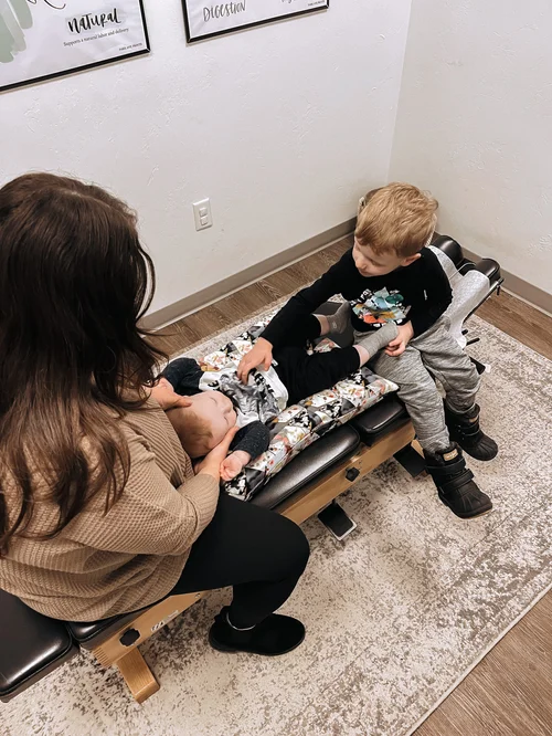Dr. Molly Mehlman providing gentle chiropractic care to a baby and toddler